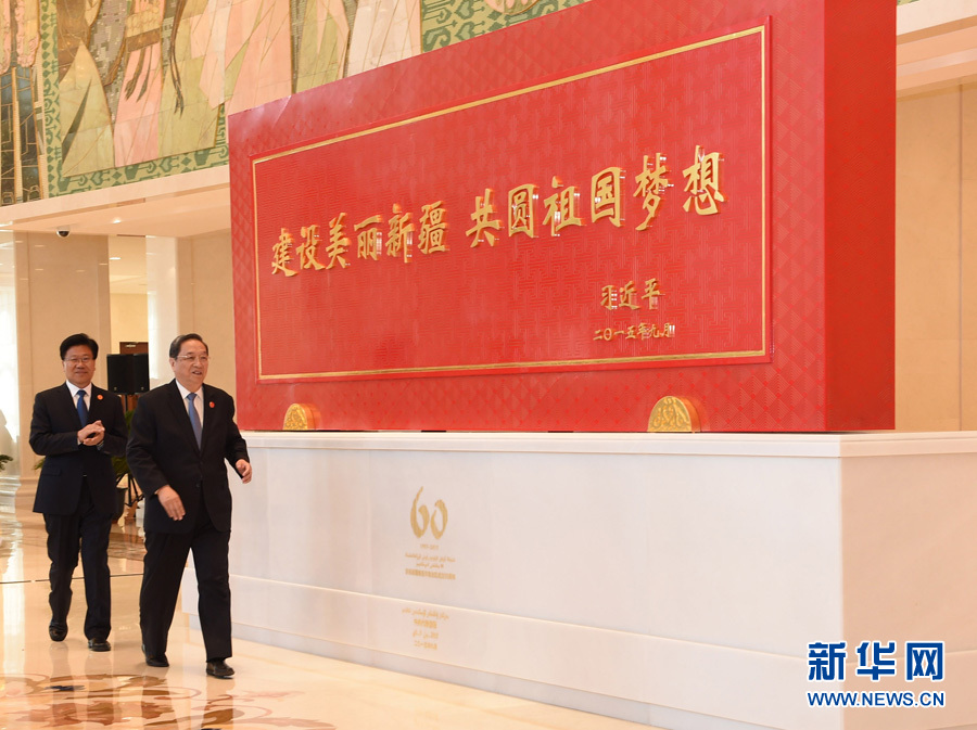 這是俞正聲和中共中央政治局委員、新疆維吾爾自治區(qū)黨委書記張春賢一同為習近平總書記題詞賀匾揭幕。新華社記者 高潔 攝 