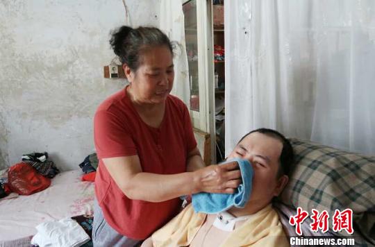 每次喂完食物后，梁青蘭都要仔細地幫兒子清理干凈。　尚明俠 攝